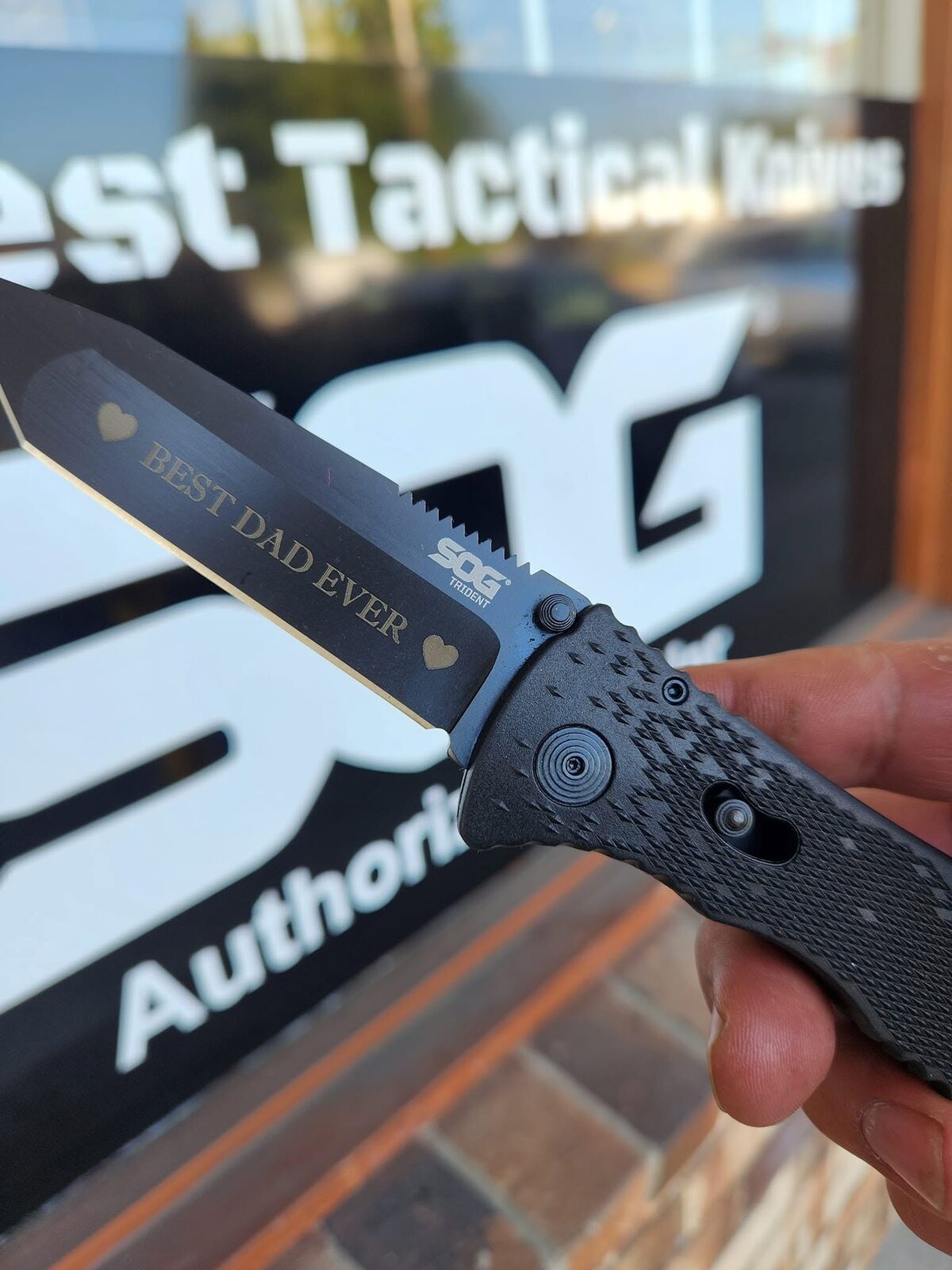 A SOG Trident folding knife laser-engraved with BEST DAD EVER